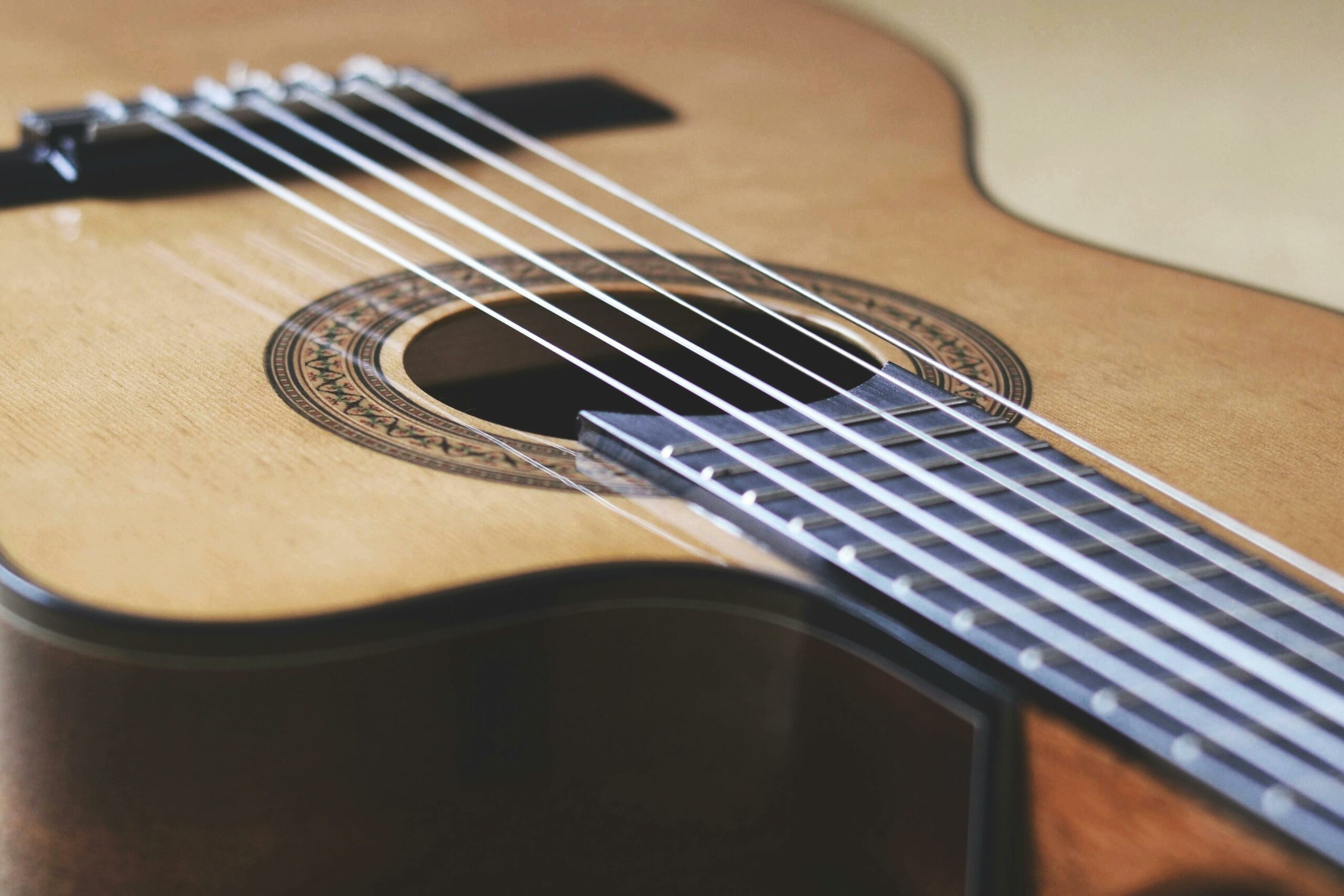 L'école d'Art's Detailed close-up of a classical guitar focusing on the strings and soundhole.